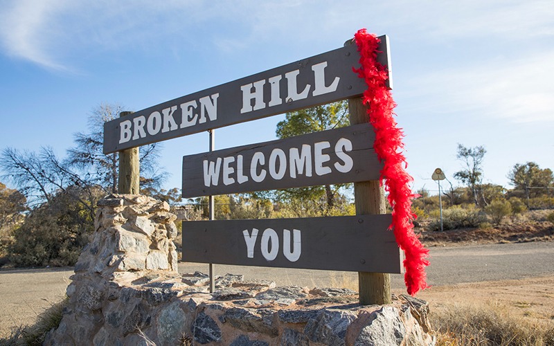 Broken Hill welcome sign with red feather boa hanging on it