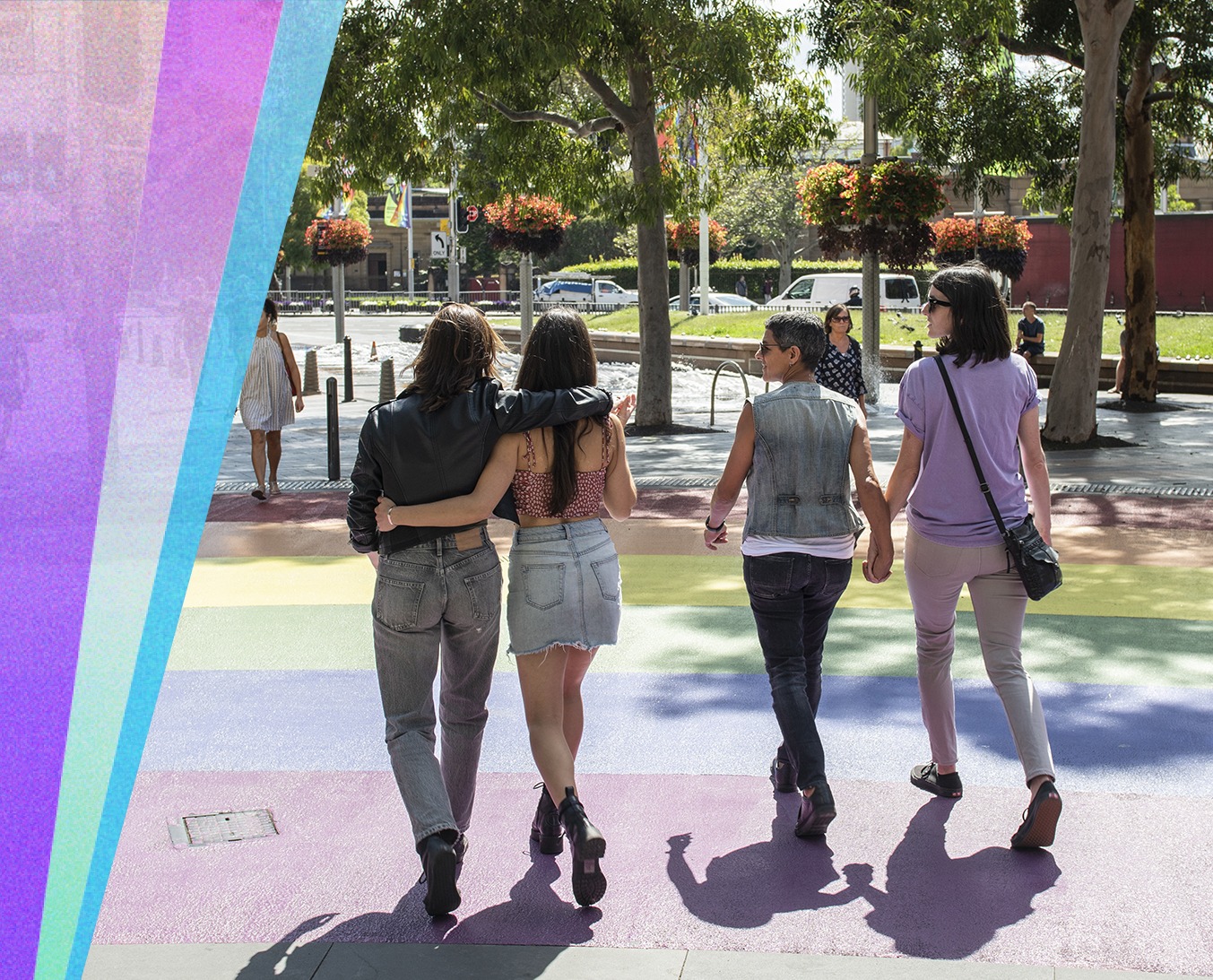 A square banner, on the left is some coloured graphical elements that look like stylised rays of light and on the right two queer couples can be seen walking with their arms around each other over the rainbow crossing at Taylor Square