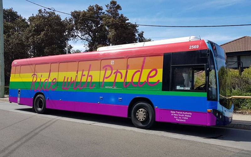 Sydney bus with pride flag wrap that says "Ride with Pride"